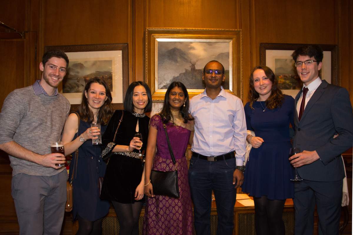 Group photo in front of paintings at Christmas 2018 party