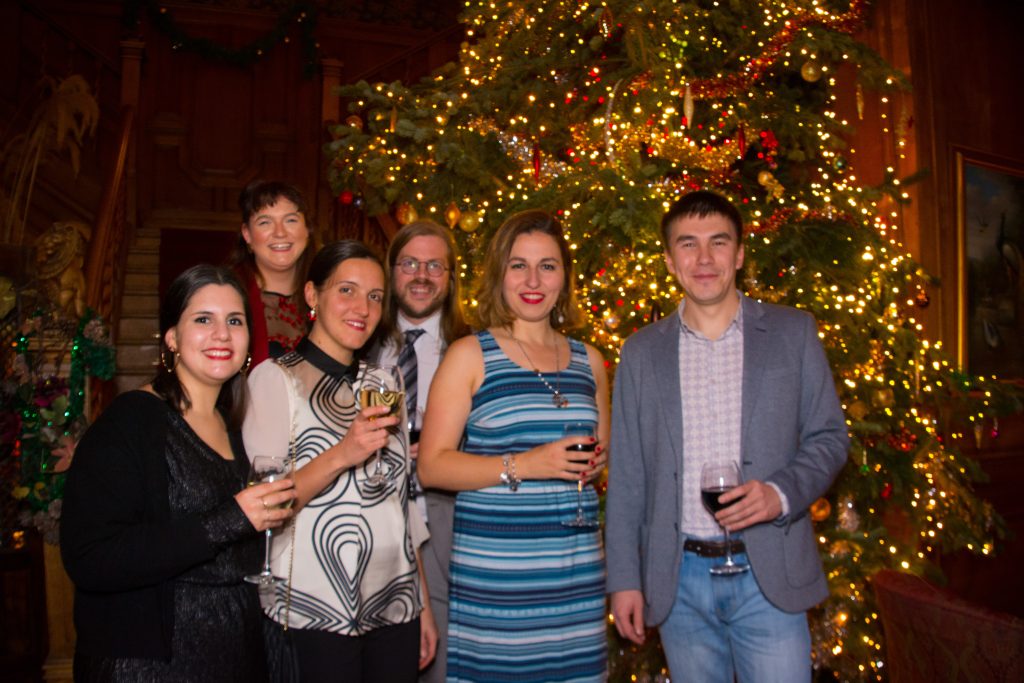 Group standing in front of christmas tree at 2018 party
