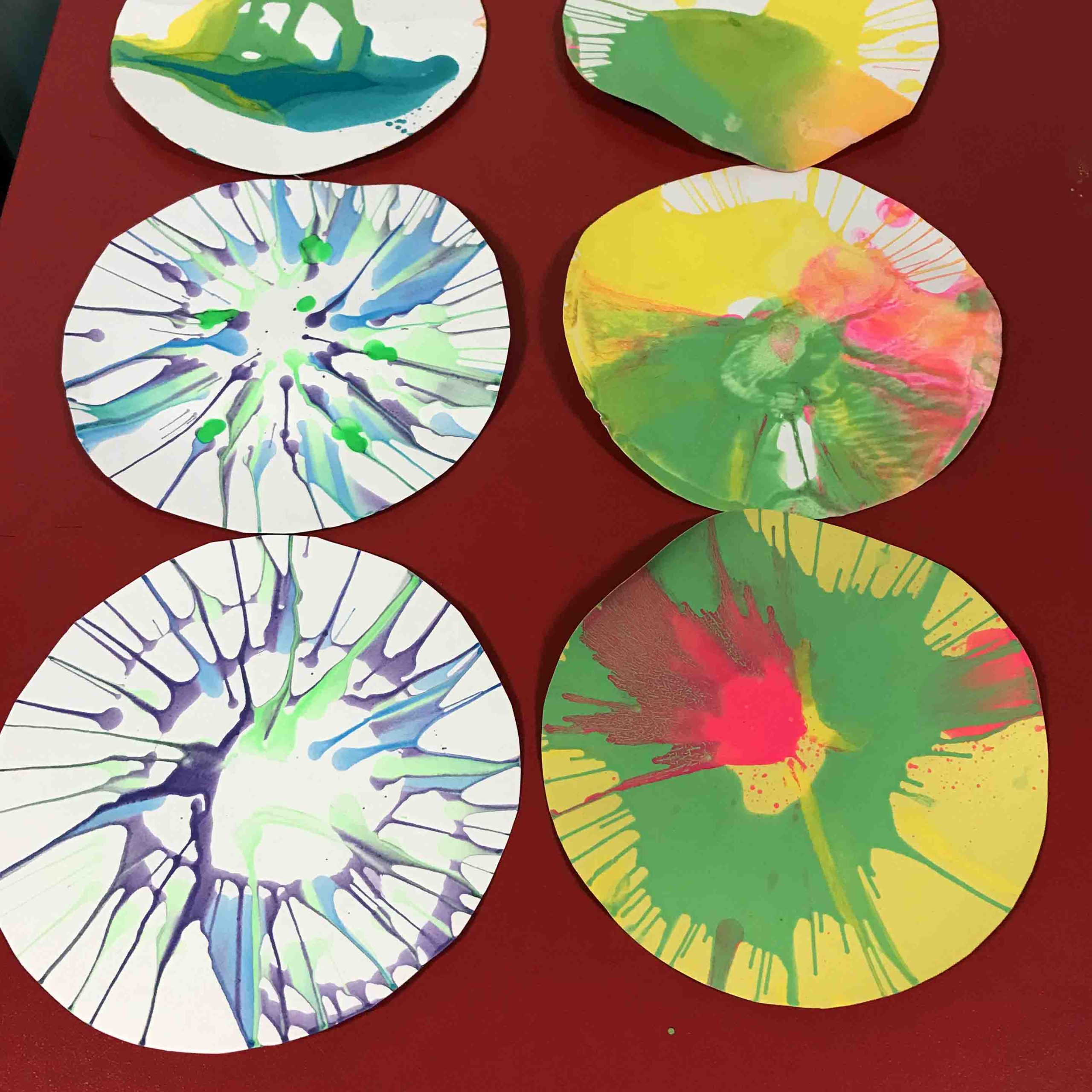 Image of circular paintings with paint spraying in a spin pattern