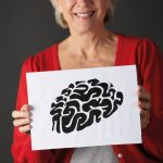 Senior woman holding ink drawing of brain