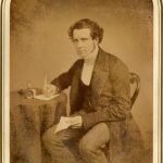 A J Halley writing at desk