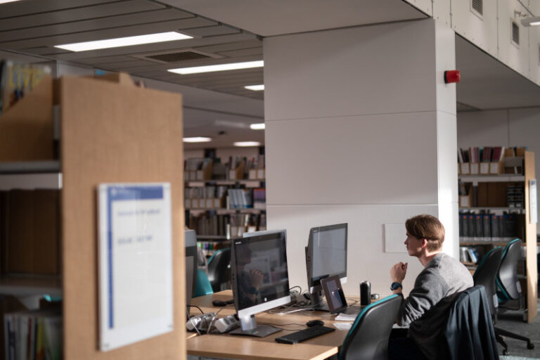 Student studying at a computer on the second floor of the Main Library
