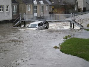 Car under footbridge during floods