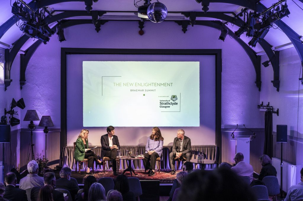 A panel of speakers sitting on a stage