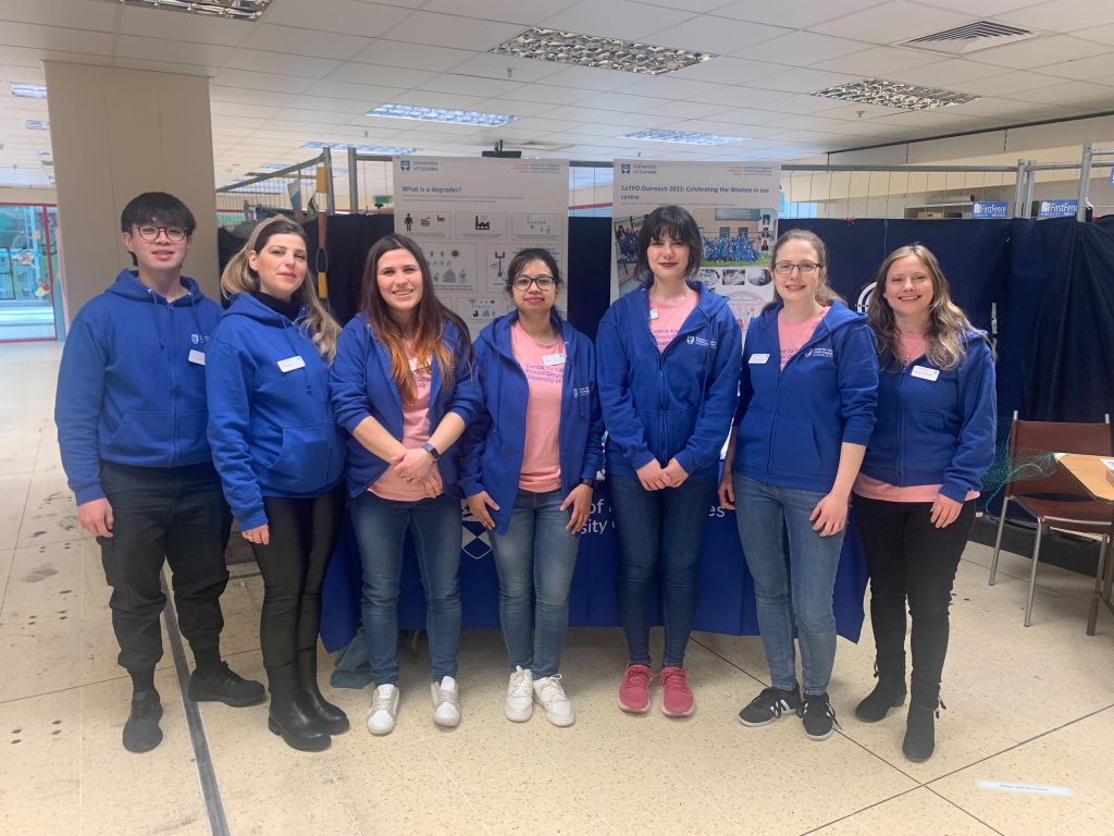 CeTPD outreach group photo taken on the outreach day in front of banners March 2023